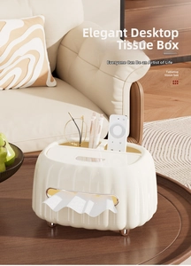 Detail of cream tissue box with gold feet and storage compartments on a wooden tray