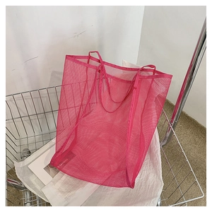 Dettaglio della borsa tote in rete rosa acceso con trama a nido d'ape traspirante