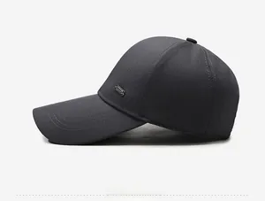 Détail de la casquette de baseball gris foncé montrant la texture et le logo métallique