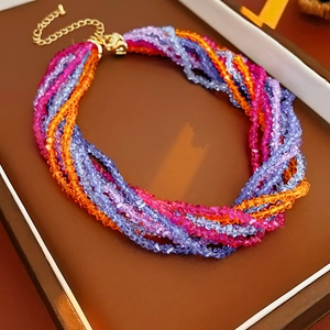 Detailed shot of multi-layer colorful beaded necklace with gold clasp in a jewelry box