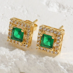 Macro shot of vintage gold stud earrings with square green zircon and diamond halo