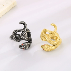 Dettaglio macro di anelli a serpente in acciaio oro e argento con occhi rossi e squame