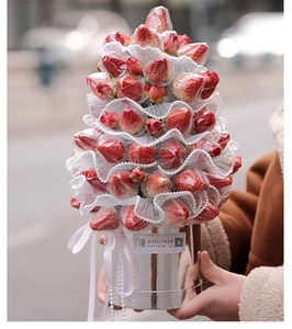 Close-up of a creative strawberry bouquet with lace and pearls in a silver gift bucket