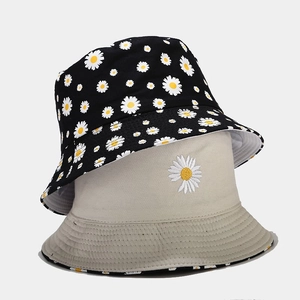 Reversible daisy bucket hat in black with floral print and beige with daisy embroidery
