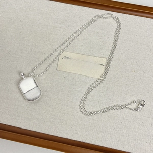 Detailed close-up of a silver perfume bottle pendant with diamond-textured finish and bead chain