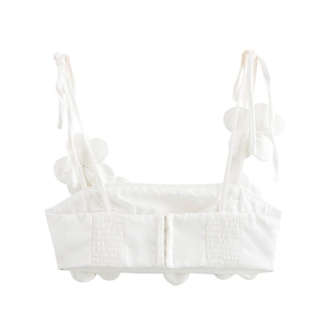 Detail eines weißen Crop-Tops mit 3D-Blumenstraps und gerafftem Rücken mit Hakenverschluss