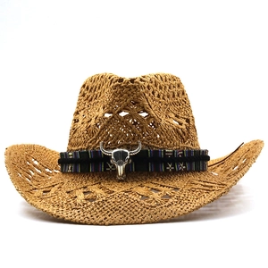 Detail of hollow-out straw fedora featuring a vintage black band and silver bull skull accent