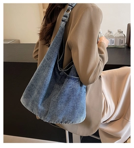 Detailed close-up of blue denim tote bag with vintage texture and metal ring strap detail
