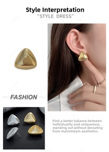 Macro shot of geometric triangle studs in polished 18k gold and silver finishes