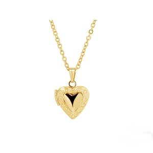 Macro shot of gold heart-shaped locket pendant with vintage floral embossed texture