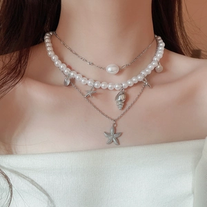 Detailed close-up of multilayer starfish and shell necklace with baroque pearls