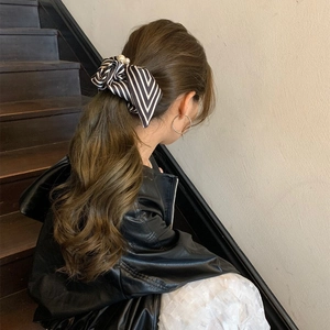 Elegant black and white striped bow scrunchie with pearls on a high ponytail