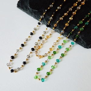 Detail of colorful faceted crystal beads and gold spacer beads on a titanium necklace