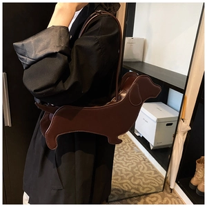 Detailed view of dark brown dachshund shaped PU leather shoulder bag on a model