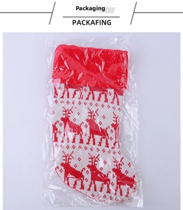 Detail view of a red and white knitted Christmas stocking with reindeer pattern in packaging
