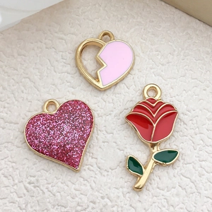 Detail of gold-rimmed pink heart and red rose oil-drop alloy pendants for jewelry DIY