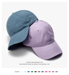 Detail of cotton baseball cap texture showing navy and lavender panels with metal eyelets