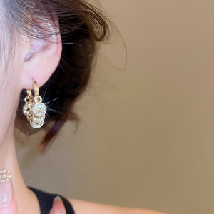 Nahaufnahme goldener chinesischer Münzohrringe mit Kristallen an einem Model