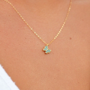 Close-up of S925 silver butterfly necklace with turquoise stones on gold-plated chain
