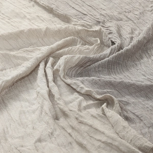 Detailed macro view of the wrinkled grey-beige fabric texture on this casual men's scarf