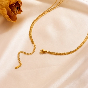 Elegant gold double-layered necklace with moon and star pendants on beige silk
