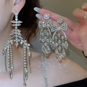 Detailed view of silver tassel earrings with sparkling crystals on a female model
