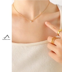 Detailed view of sparkling cubic zirconia pendant and gold stainless steel ring set