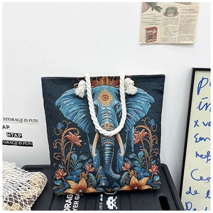 Detailed embroidery of elephant and floral motifs on a canvas tote with rope handles