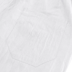 Close-up of white linen polo shirt pocket showing detailed stitching and fabric texture