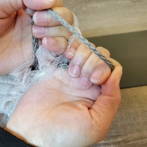 Close-up of durable gray hanging rope on a large soft dual-color mesh bath sponge shower ball