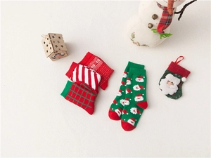 Close-up of festive Christmas cotton socks with Santa Claus patterns and striped designs