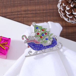 Macro view of silver Christmas tree sled napkin ring with colorful rhinestones and pearl
