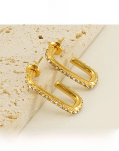 Macro shot of U-shaped gold titanium steel earrings with pave-set shimmering zircon stones