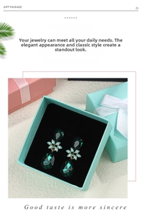 Close-up of emerald crystal teardrop earrings in a premium bow-knot gift box