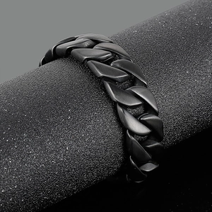 Detail of black matte titanium steel Cuban link bracelet with brushed metal texture