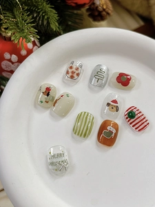 Detailed Christmas nail art stickers featuring festive patterns on a white ceramic plate