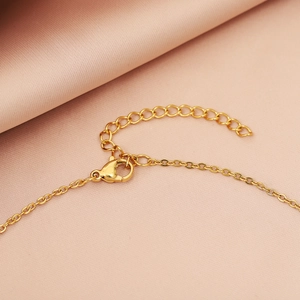 Detailed close-up of gold U-shaped pendant necklace with lobster clasp and extension chain