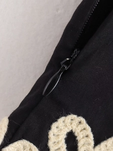 Gros plan d'une fermeture éclair invisible et d'une bordure en crochet sur tissu noir