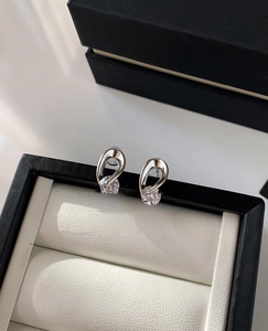 Detailed close-up of zircon stud earrings in a white jewelry box with 45-degree angle