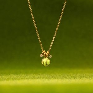 Detail der goldenen Baseball-Halskette mit neongrüner Emaille und Kristallbesatz