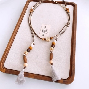 Detailed macro view of bohemian wooden beads and cotton tassels on a natural cord belt