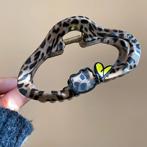 Close-up of leopard print hair claw with black kitty cat silhouette and yellow heart detail
