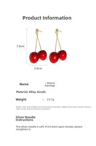 Detail showing long red acrylic cherry earrings with golden chains and dimensions