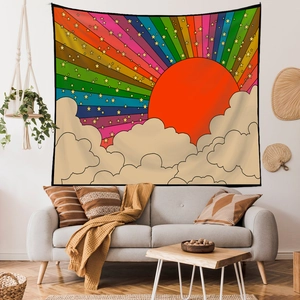 Detail of bohemian rainbow tapestry with sun and stars hanging above a sofa