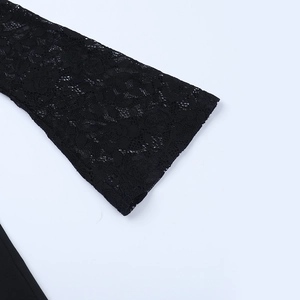 Gros plan détaillé sur la dentelle noire et les poignets évasés d'une combinaison