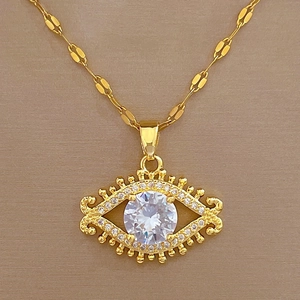 Macro shot of gold evil eye pendant with sparkling white cubic zirconia and pave rhinestones