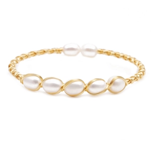 Minimalist woven gold wire bracelet featuring natural freshwater pearls on white background