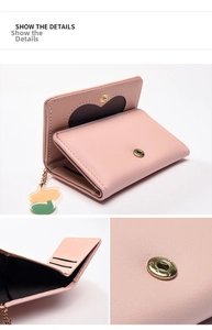 Detail view of pink trifold wallet showing interior card slots and heart-shaped window
