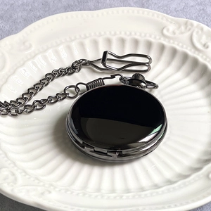 Vintage Alice in Wonderland pocket watch with chain on a white embossed plate