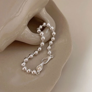Minimalist 925 sterling silver bead bracelet with pearl charm on cream ceramic